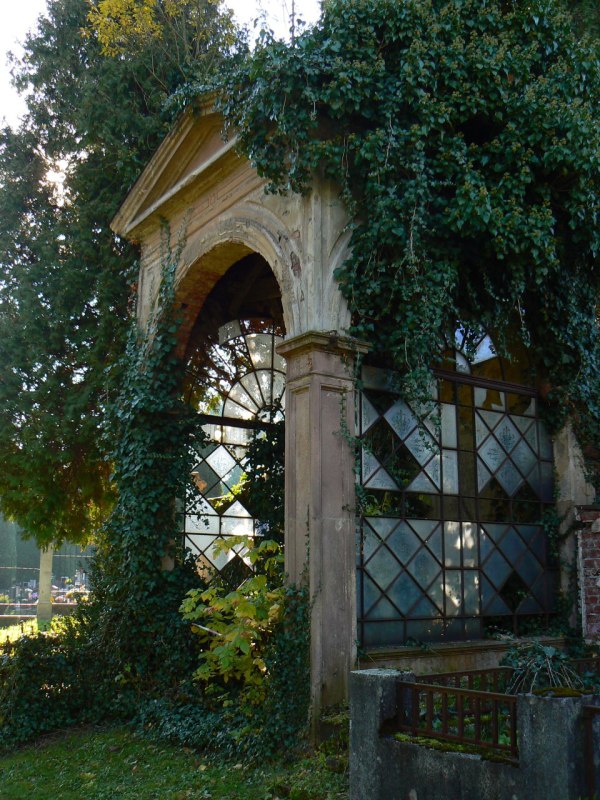 Klasicistní hrobka, zarůstající záplavou zelených listů břečťanu
