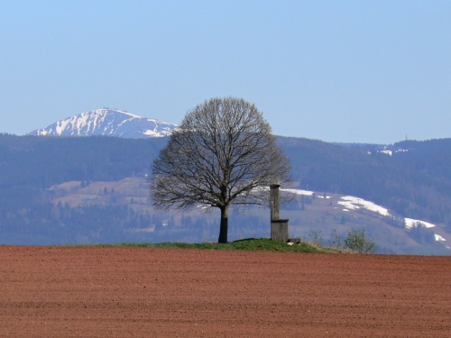 Kaple z protějšího pohoří, přitažená optikou fotoaparátu a za ní Sněžka